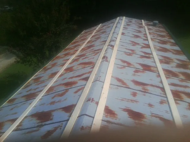 Rusted metal roof panels with new wood purlins before replacement — Storm Damage Roof Repair in Belle Haven by Roofing Brothers