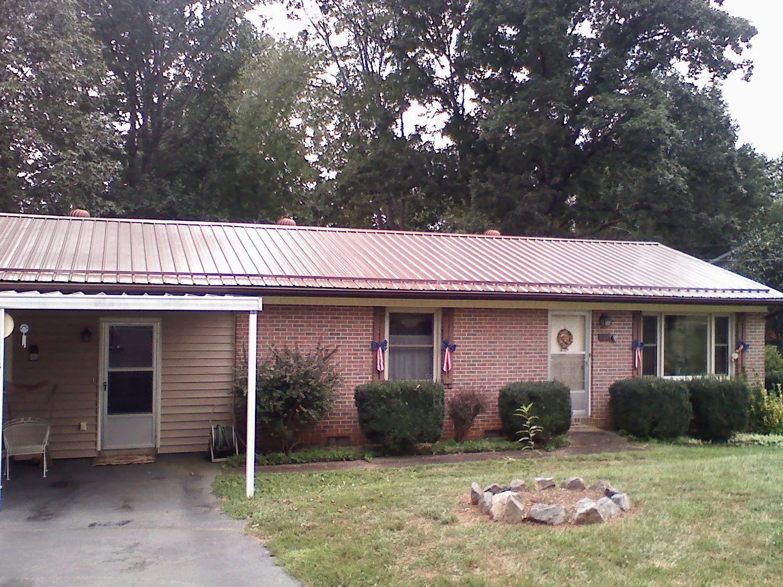 Bronze metal roof and carport on a brick ranch home — Roof Repair work by our crew in Belle Haven