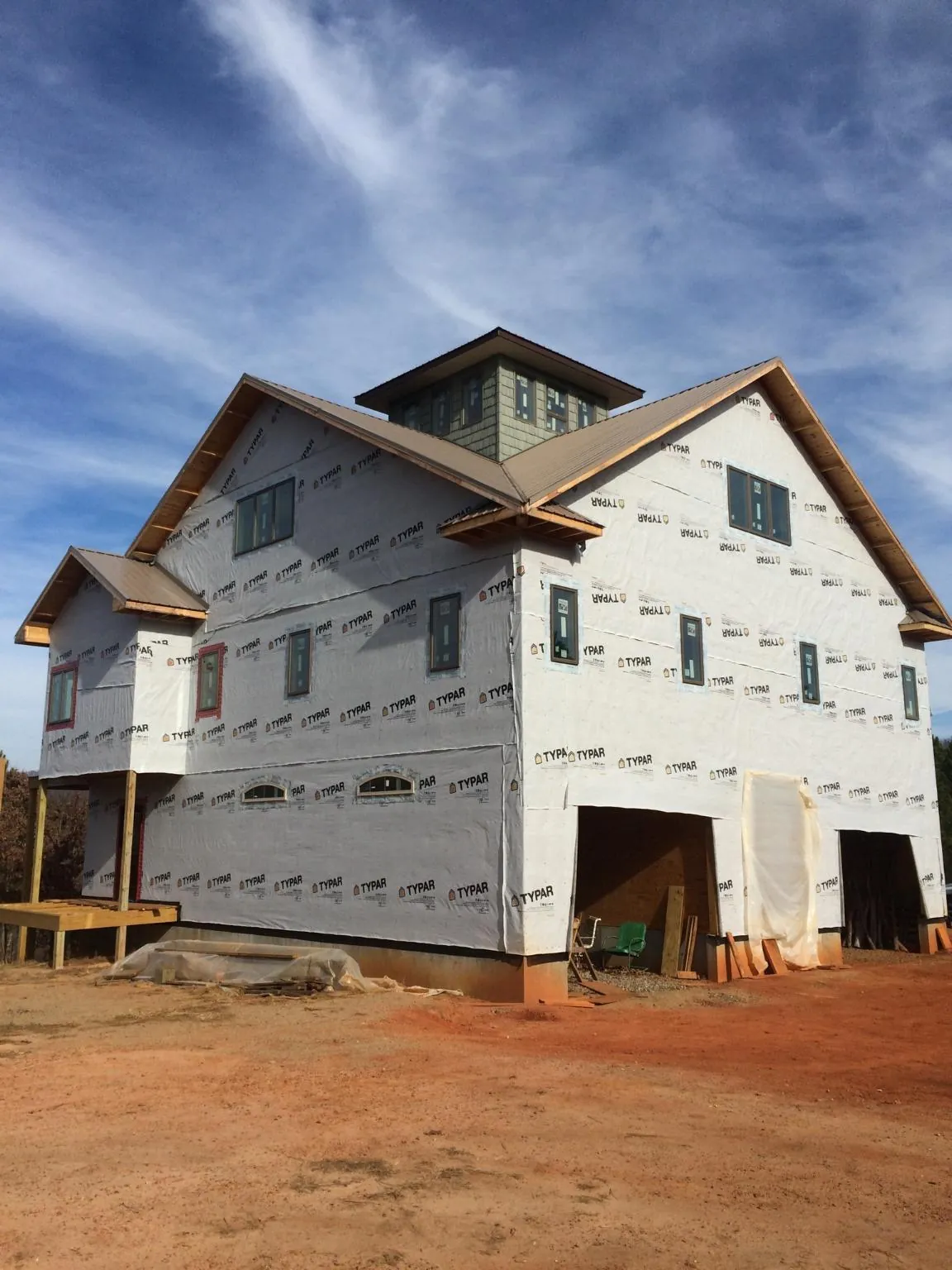 New two story house under construction with a cupola and gabled roofs in Belle Haven